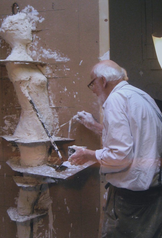 Arbeit an Gipsfigur, die noch von den Vergrößerungsschablonen umgeben ist